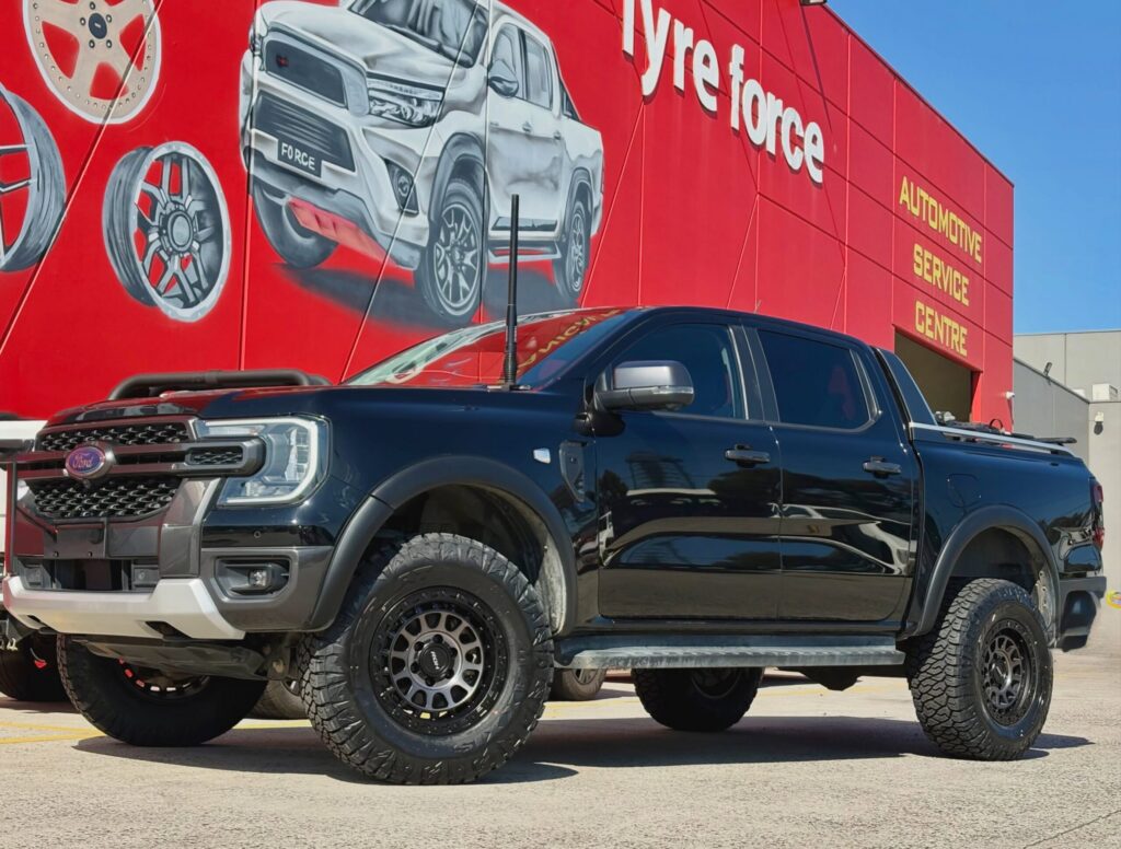 Black Ford Ranger with dark alloy wheels and off-road tyres outside the Tyreforce showroom.