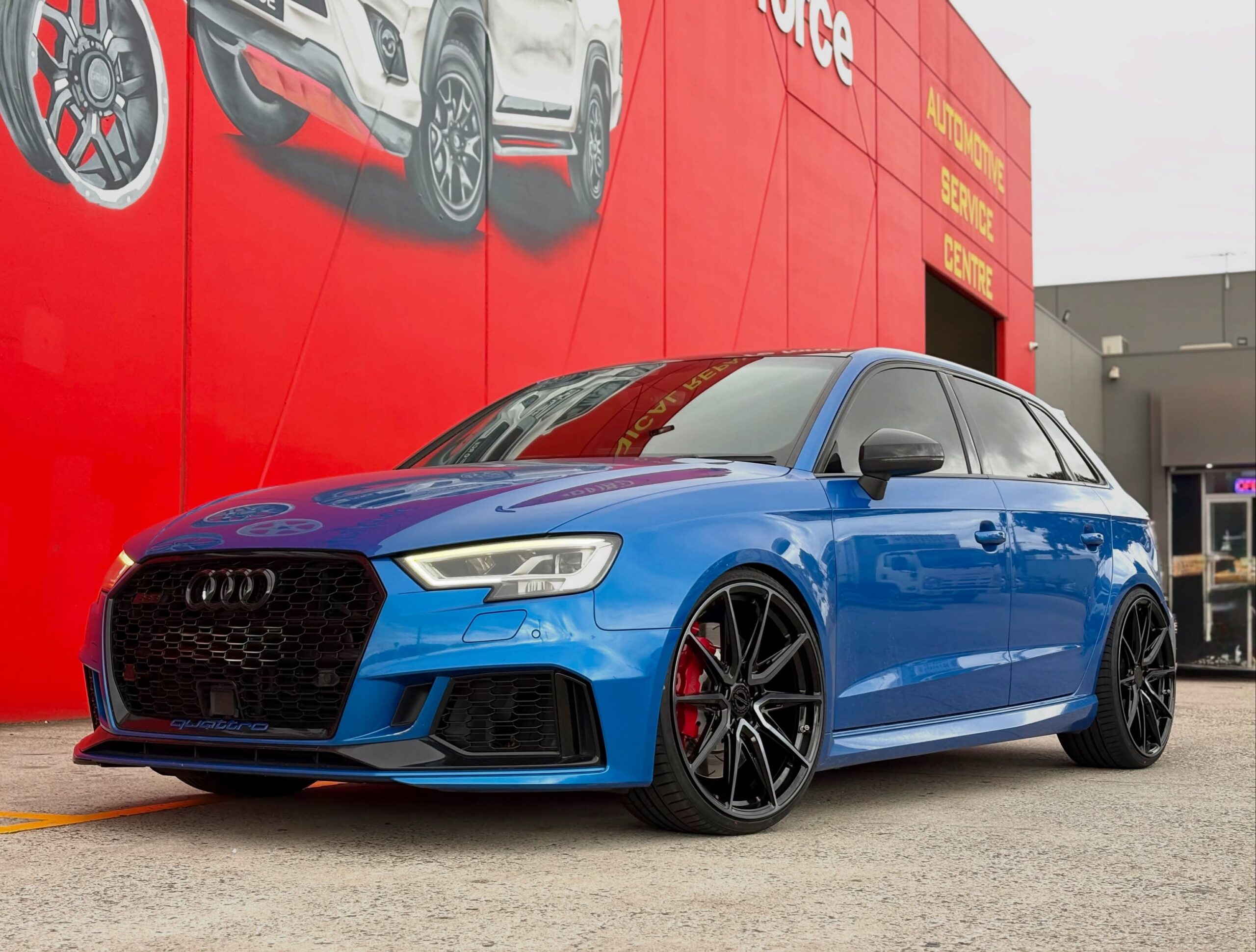 Blue Audi Sportback with dark multi-spoke alloy wheels outside Tyreforce.