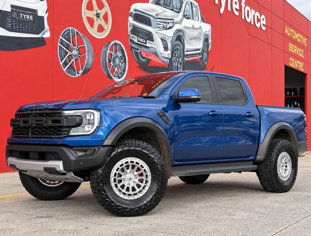 Blue Ford Ranger Raptor with silver alloy wheels and all-terrain tyres outside Tyreforce.