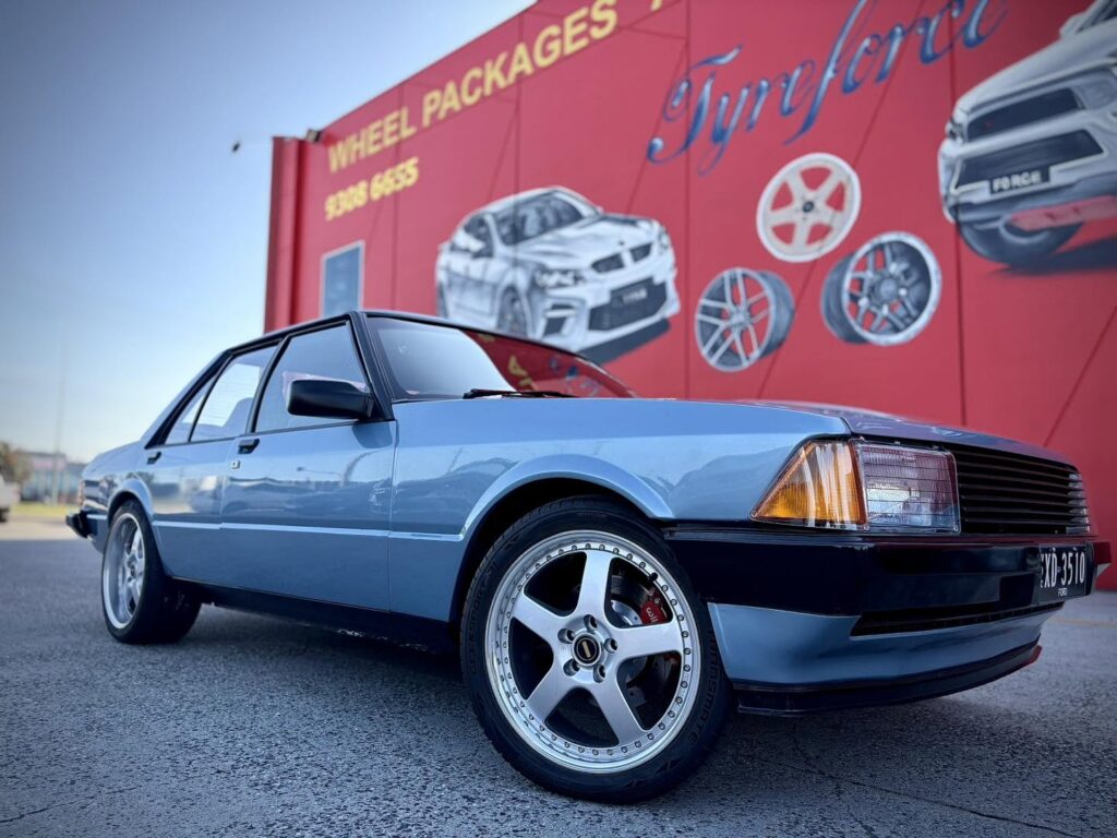 Blue classic Ford Falcon with silver five-spoke alloy wheels outside Tyreforce.
