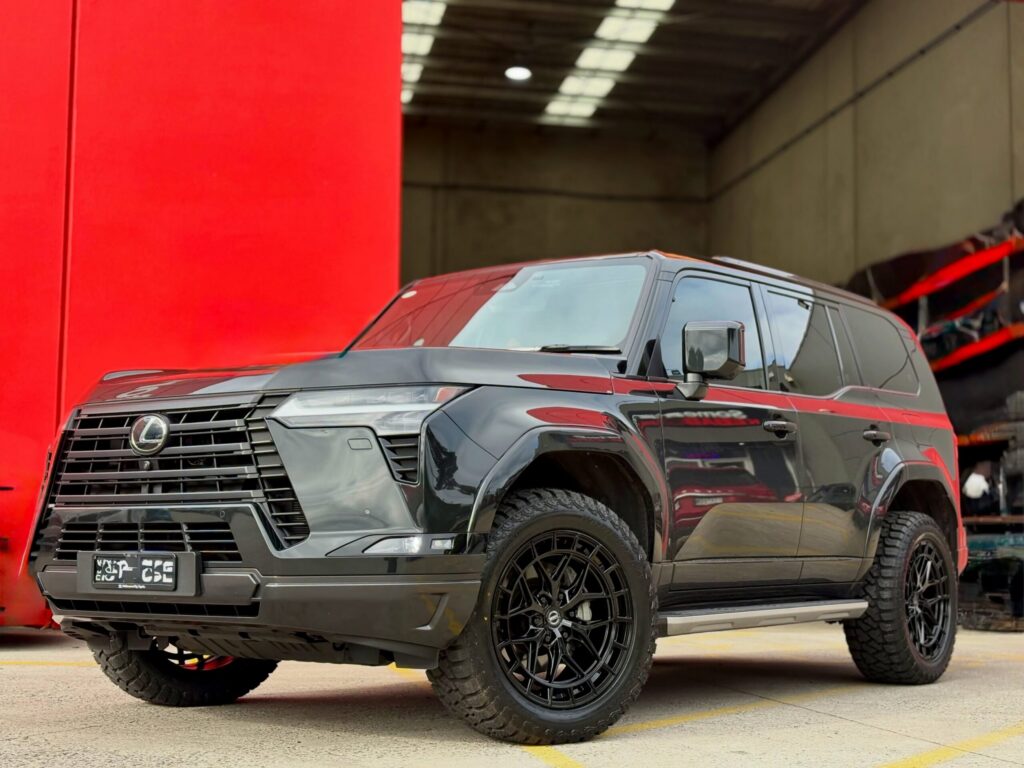Dark Lexus GX with black alloy wheels and all-terrain tyres at the Tyreforce workshop.