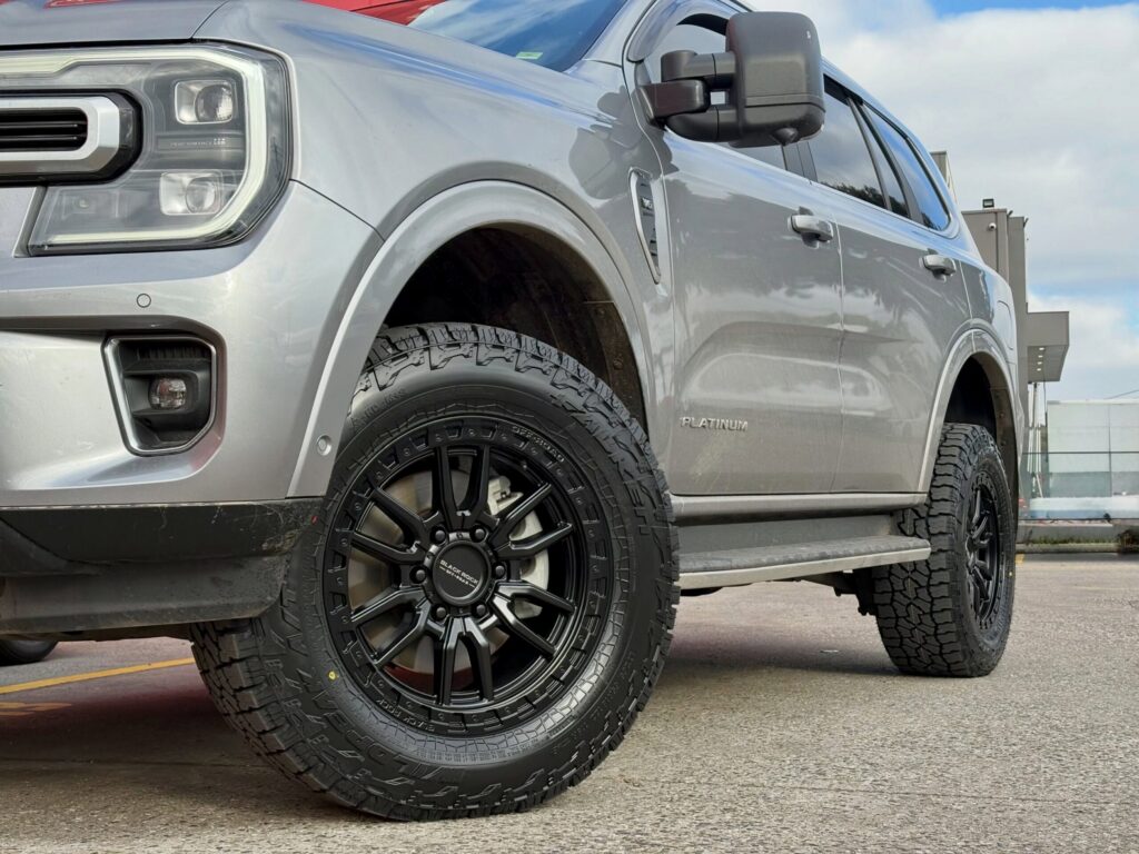 Close-up of black alloy wheels and off-road tyres on a silver Ford Everest Platinum.